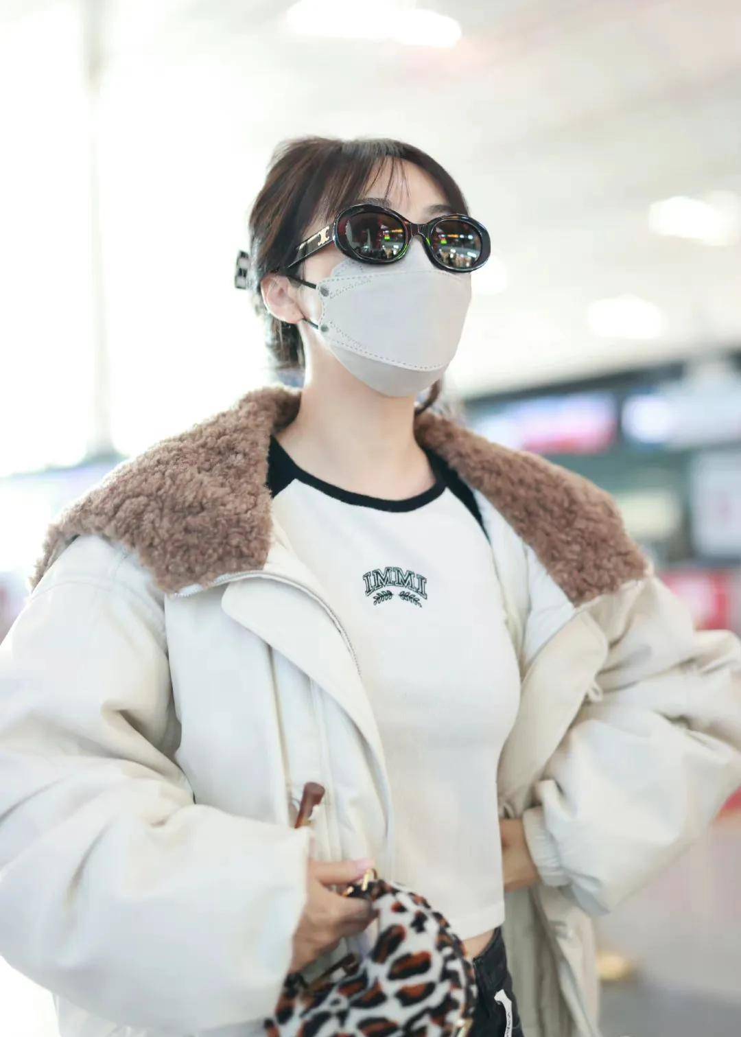 李菲儿走机场穿白色翻毛领夹克搭黑色牛仔裤清新时尚显身材