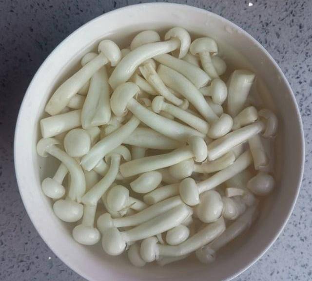 第2步,白玉菇用盐水浸泡十分钟.第3步,木耳用温水泡开洗干净撕成小朵.
