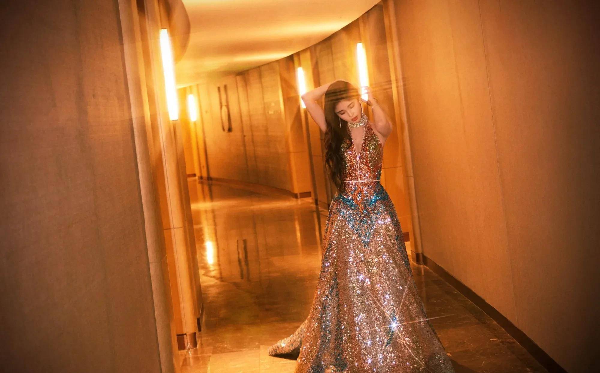 鞠婧祎出席东方风云榜音乐盛典红毯造型曝光,一袭金色流彩晚礼服,深v