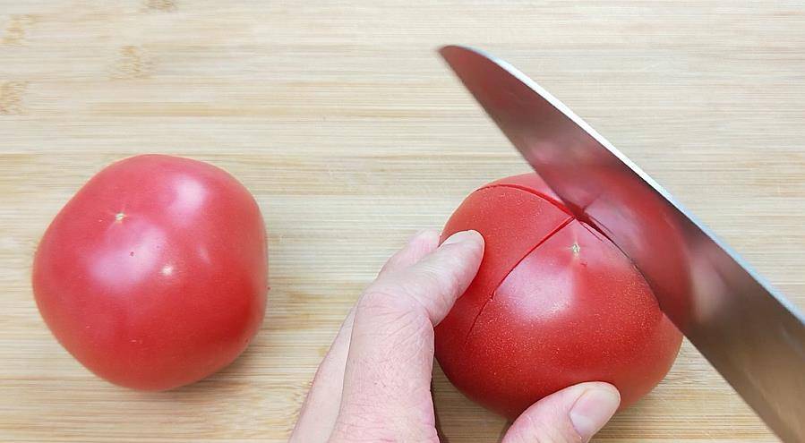 1,准备2个西红柿,洗干净之后,在上面切十字花刀西红柿鸡蛋汤