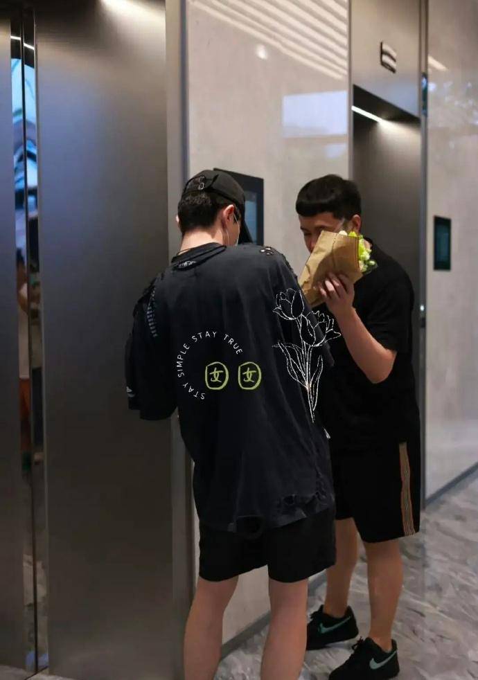 邓伦一个人拿着一摞信件,还有粉丝追到电梯口送礼物,邓伦和助理在电梯