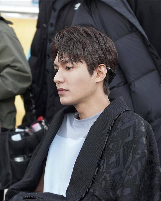 在拍戏的空档李敏镐坐在一旁等待开机,略微凌乱的发型难掩帅气,甚至有