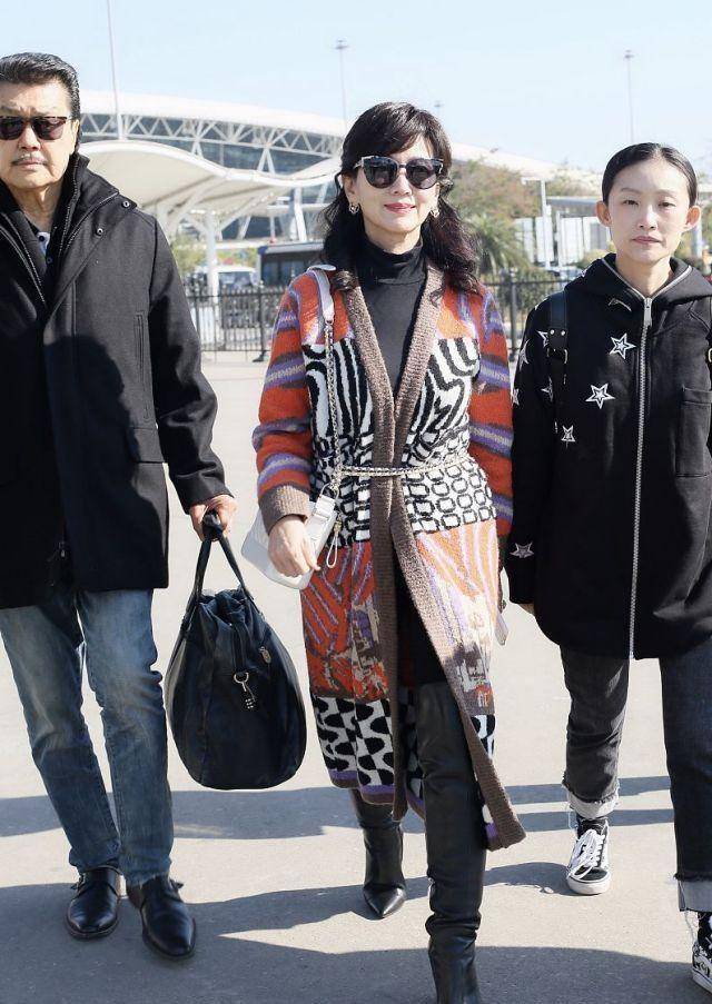 当天赵雅芝身穿一件橘红花色的针织长衫,内搭黑色毛衣脚踩
