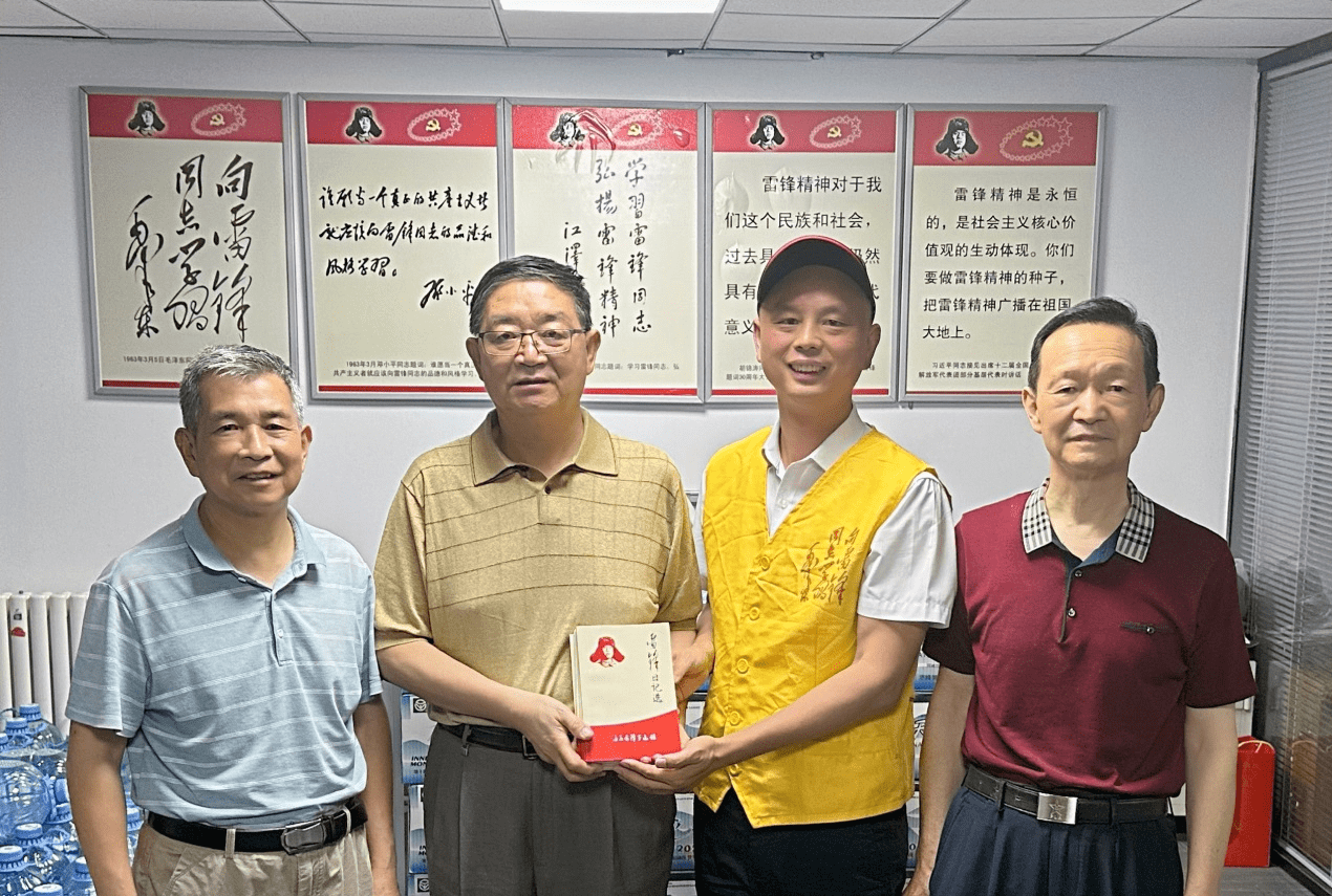 图为孙武斌秘书长向李天文主任赠送金华雷锋馆新编《雷锋日记》两批从