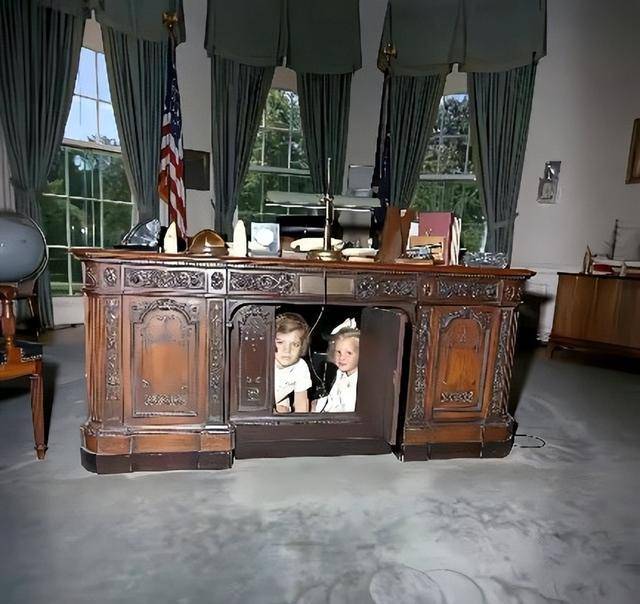 一张是卡罗琳和弟弟小肯尼迪躲在坚毅桌下和父母玩躲猫猫被抓拍的照片