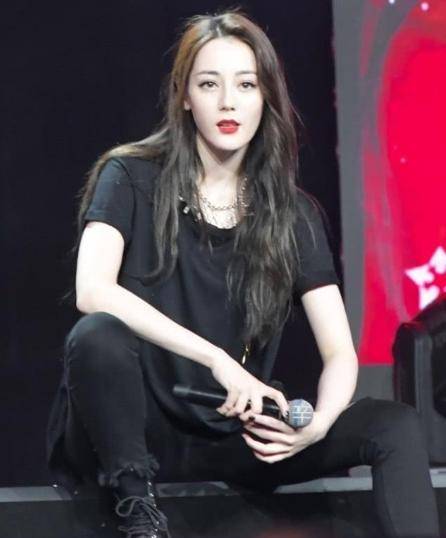 迪丽热巴的坐姿就像大佬一样霸气侧漏,而且再搭配上一身宽松的黑色t恤