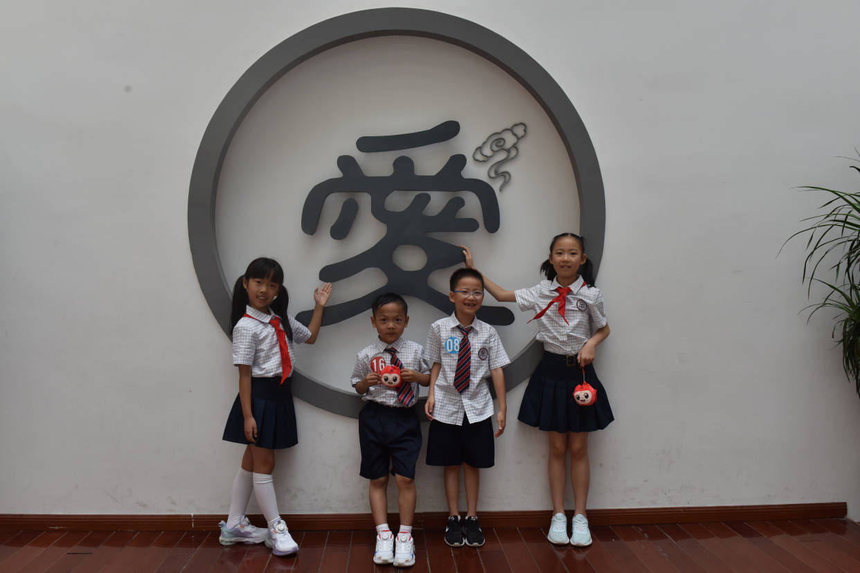 金师附小一年级新生在爸爸妈妈的陪同下,穿着整洁的新校服一起走过"十