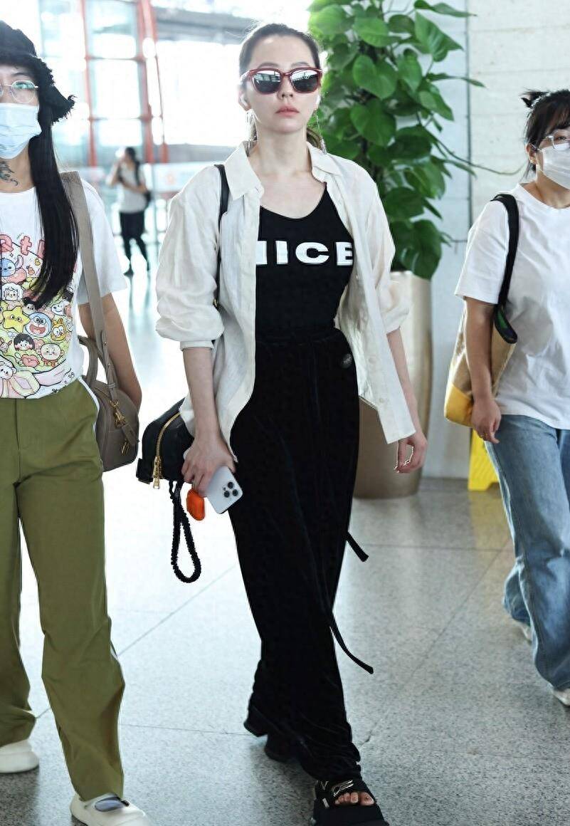 街拍:张靓颖白色外衫内搭黑色长裙酷爽简约 现身北京机场