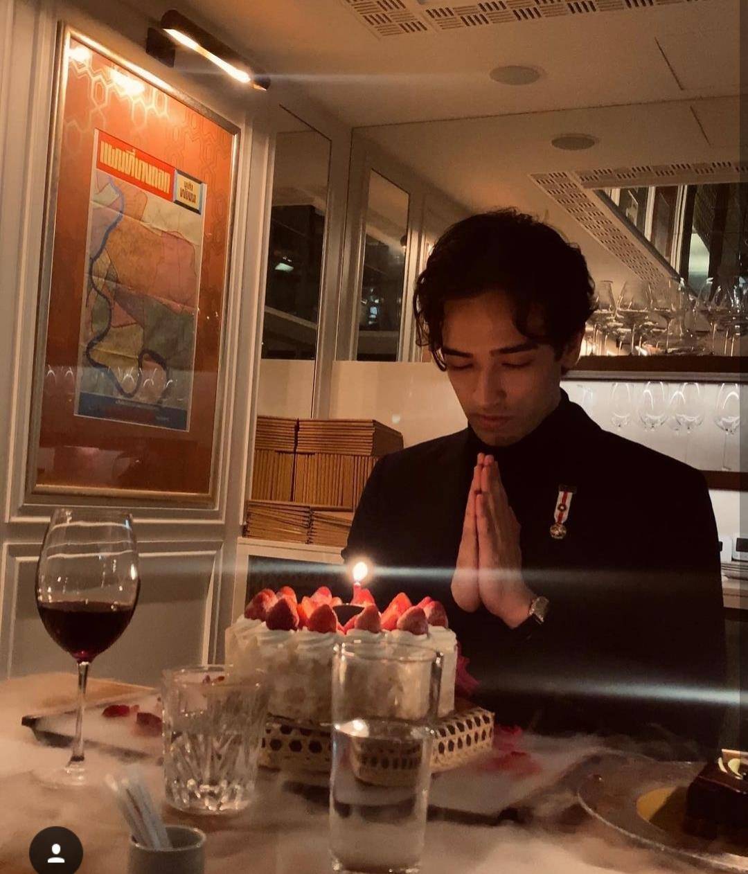 家人特意为韦紫明选了一个草莓味水果蛋糕他身穿黑色西装外套十分