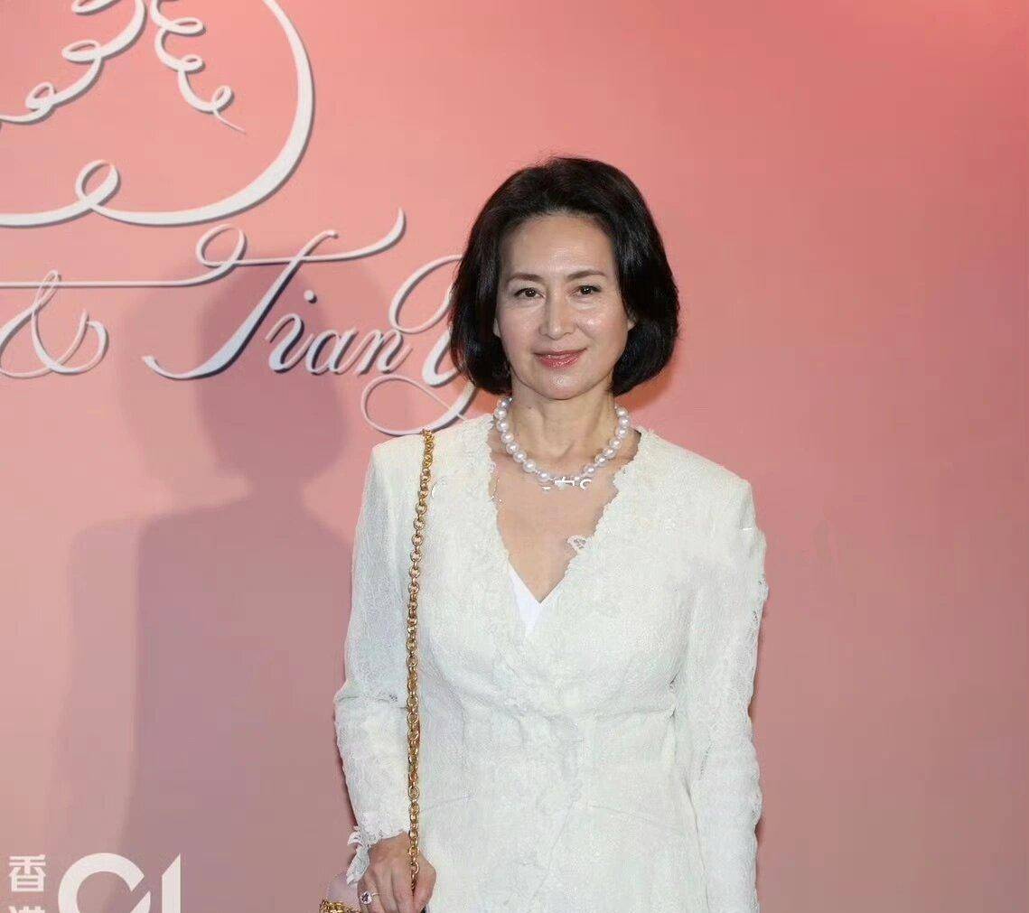 当何超琼选择米白色蕾丝外套搭配白色吊带裙时,展现了她对时尚的独特