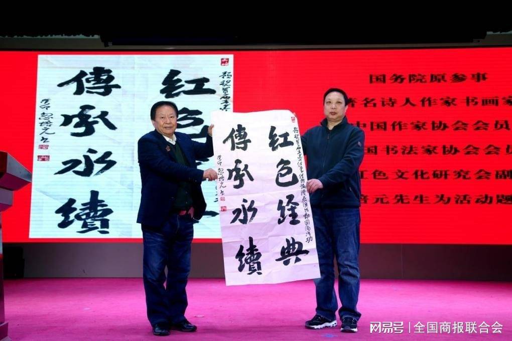 北京市昌平區第二中學副校長張雲(右)代表學校接收贈品《回延安》是