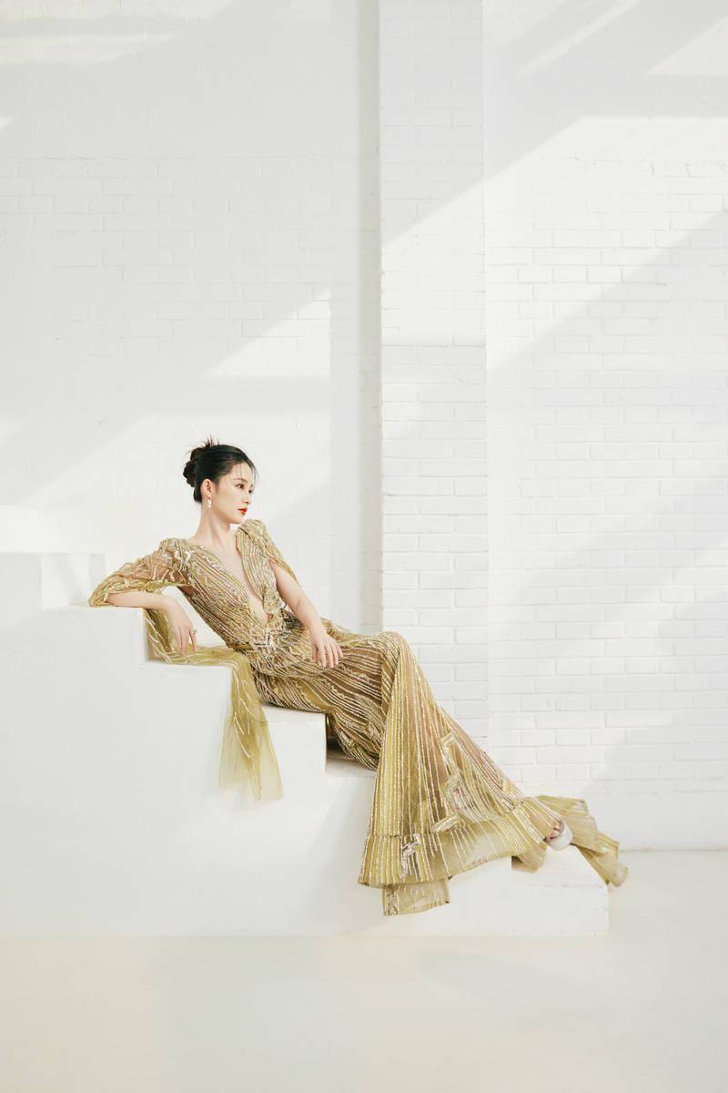 拍摄写真中,李沁身穿深v背镀金连衣裙,她站在窗边在光影下显得好美