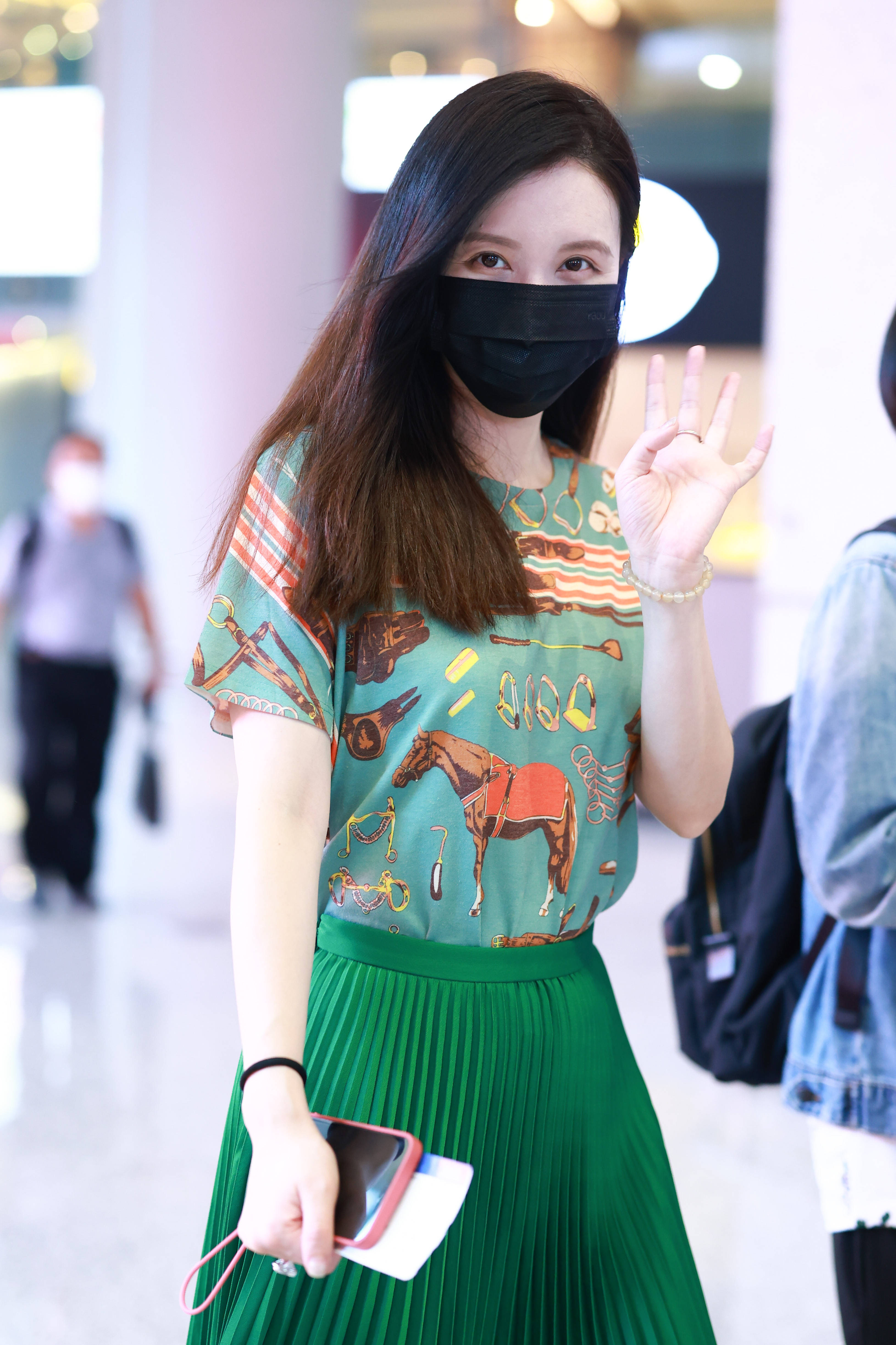 1/ 12 2021年6月27日,上海,张萌亮相机场,她身穿绿色印花t恤搭配百褶