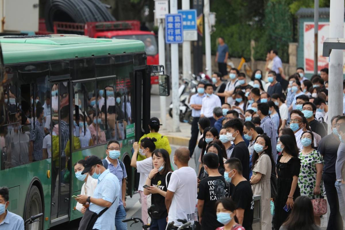 當日,在紫荊山公交車站早高峰時段,上班族一波接一波蜂擁乘車.