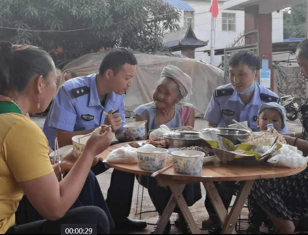 图为民警在群众家吃饭的照片