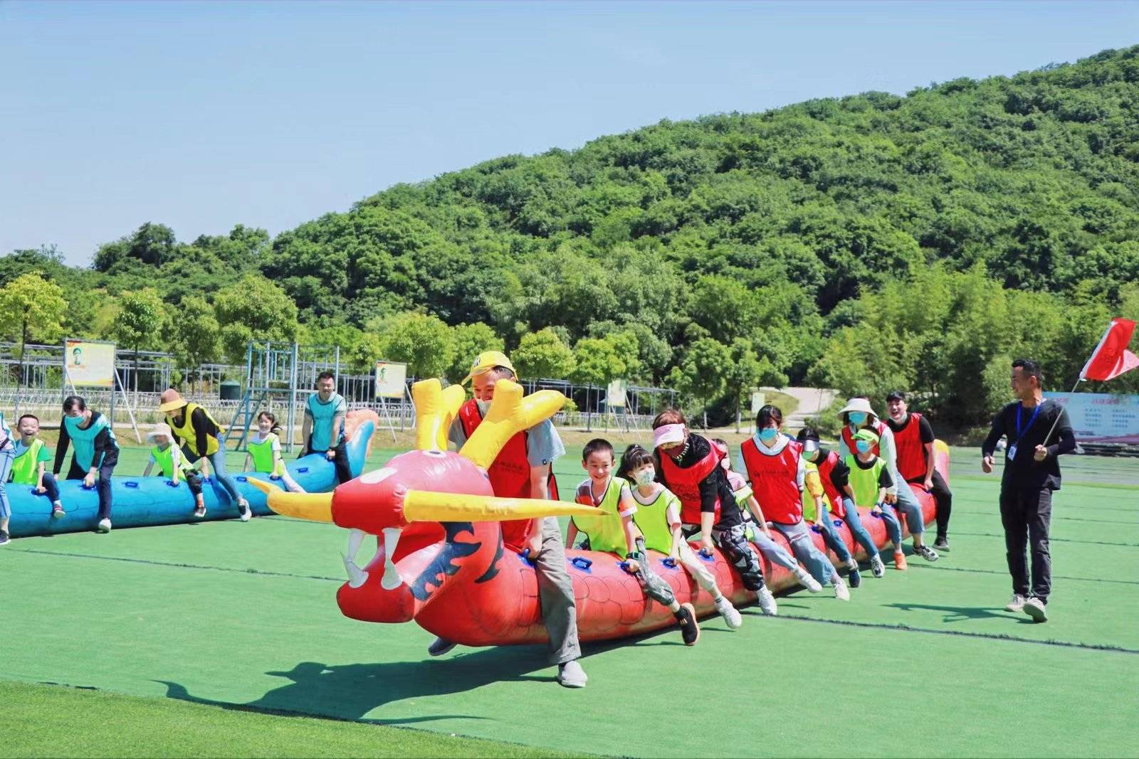 旱地龙舟:做活动的龙舟充好气,摆放哪里,家长和孩子分别坐在龙舟上