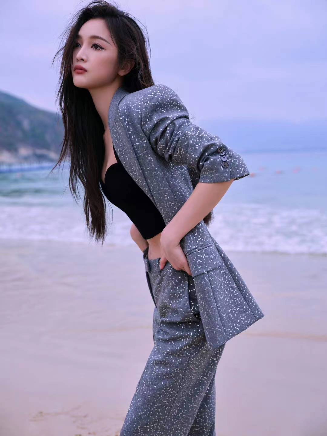 但吴宣仪在海边拍摄写真所穿的这套灰色的西装满满镶嵌了银色的亮片