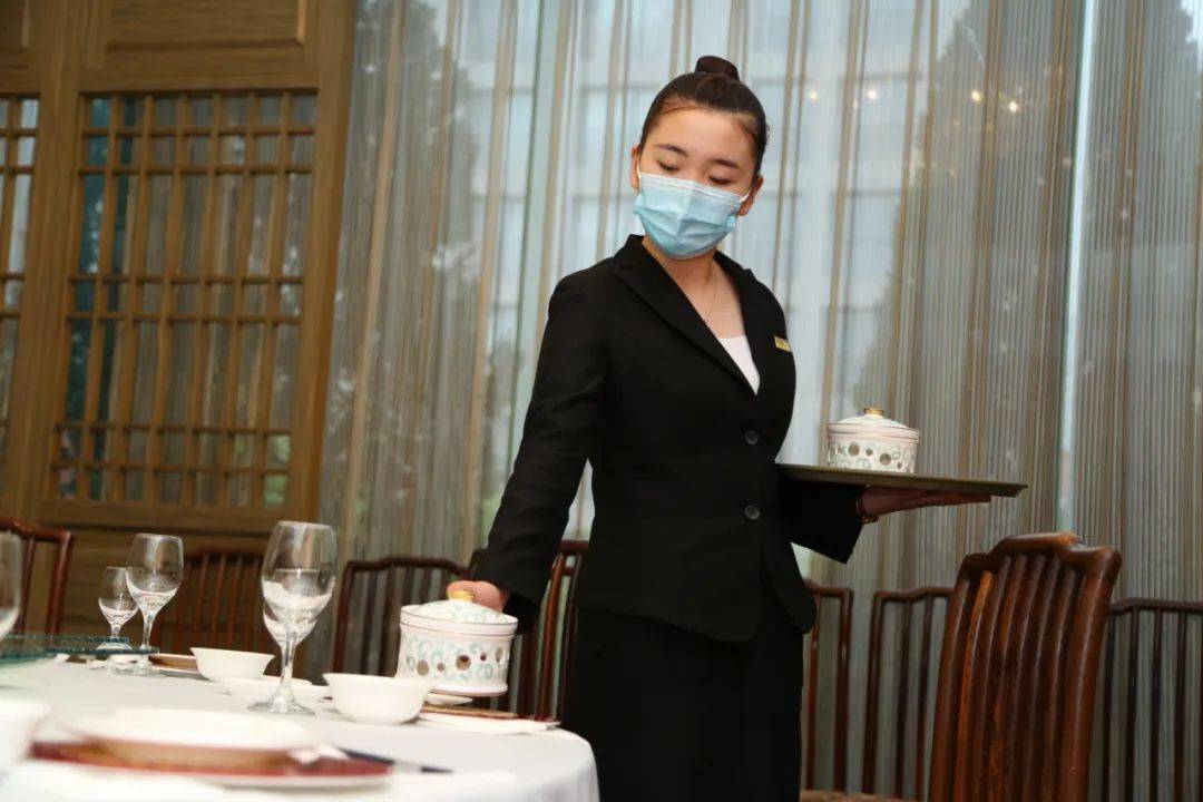 用餐时,服务人员引导客人使用分餐工具取餐.