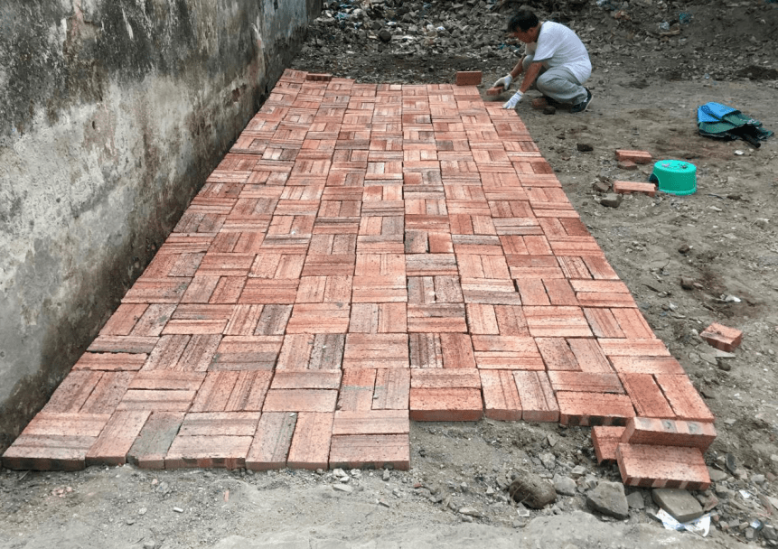 整治"铺砖行动",行动主要对卫生死角进行清理平整,地面用红砖进行铺贴
