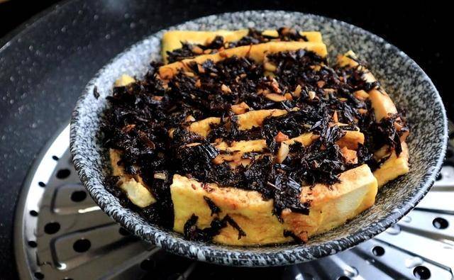 然后将豆腐倒扣过来,最后撒上一些葱花点缀增香,这道梅菜扣豆腐就做好