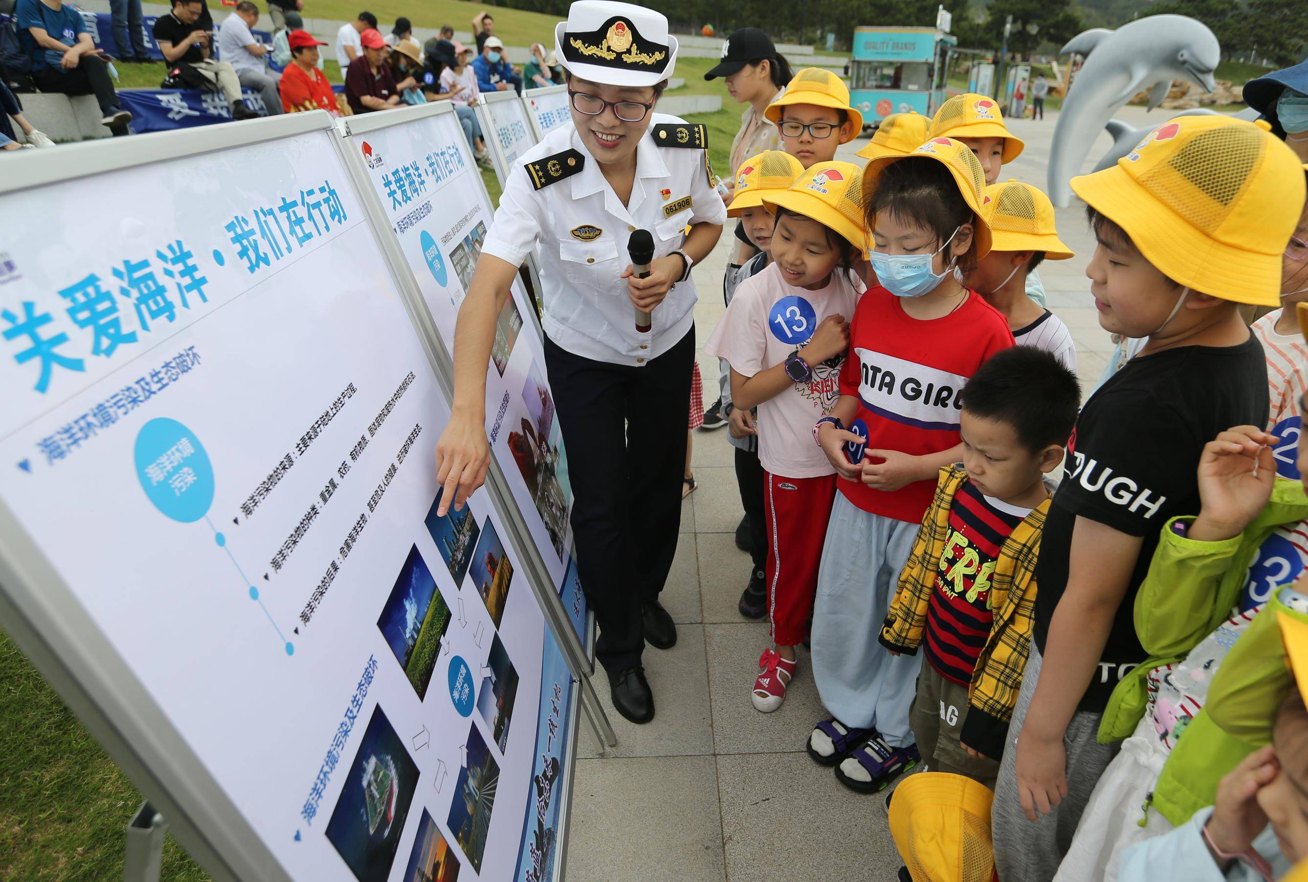 7月11日,在江苏省连云港市在海一方公园,海事人员向学生宣传保护海洋