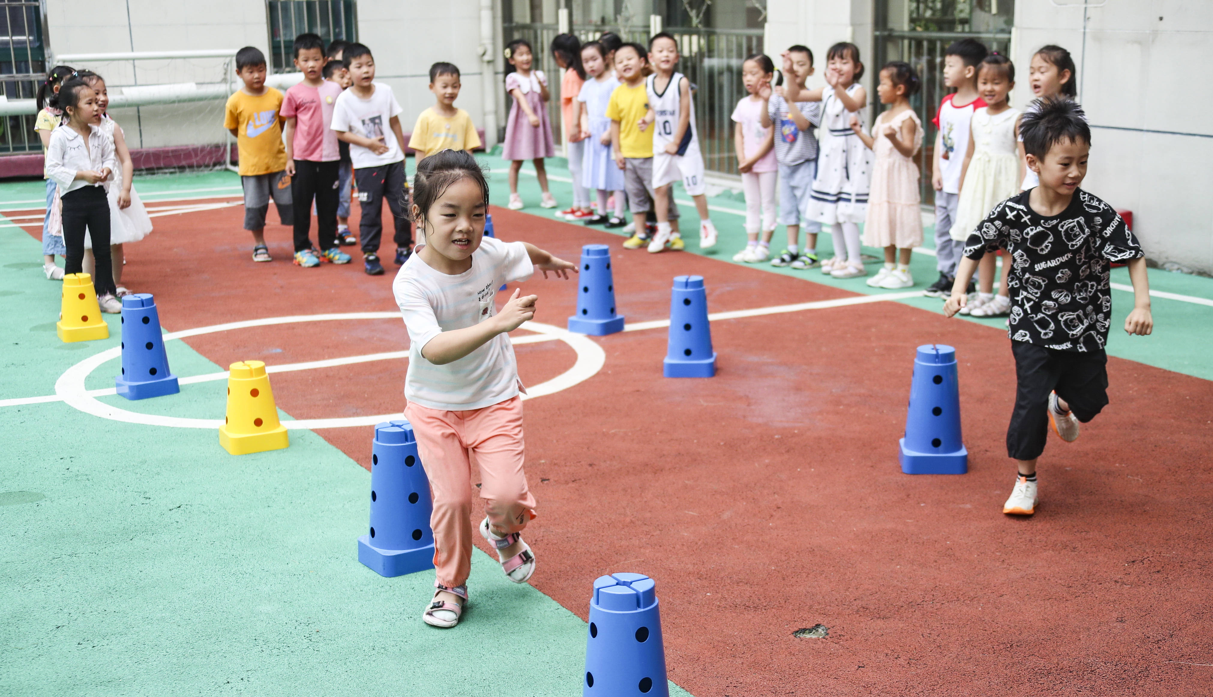 7月14日,幼儿园小朋友在进行绕桩跑比赛.