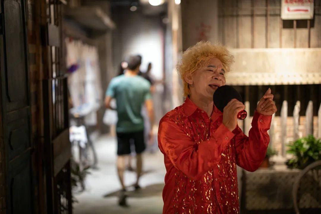 的奖杯,简单的白色瓷砖修饰,上面贴满了明哥在夜市表演的图片和海报