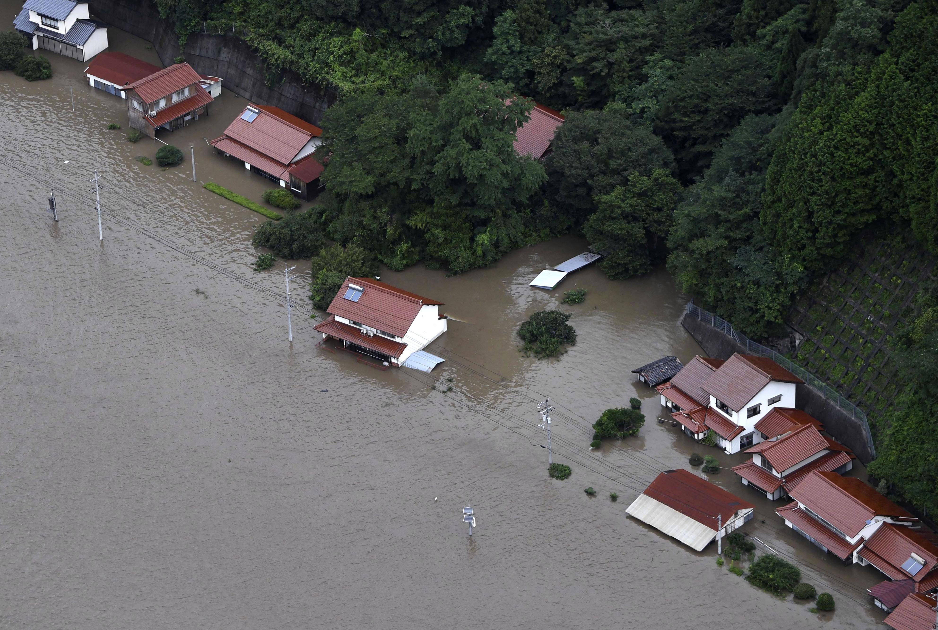 7月14日,在日本岛根县江津市,部分房屋因河流泛滥被淹