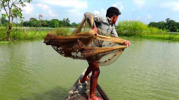 大哥撒渔网打鱼这撒网技术真老练一网下去看看能捕到啥