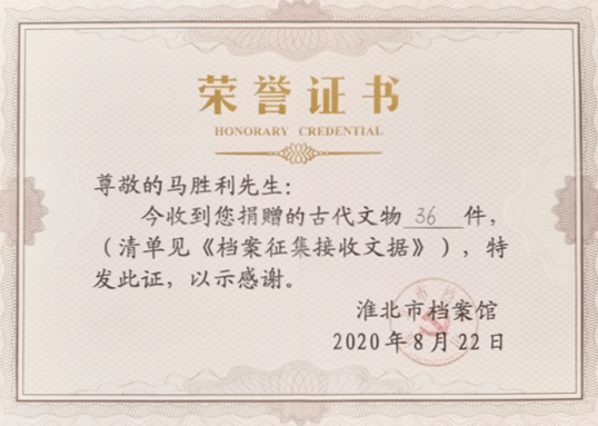 同志向退役军人马胜利颁发捐赠证书,对他无偿捐赠文物表达由衷感谢
