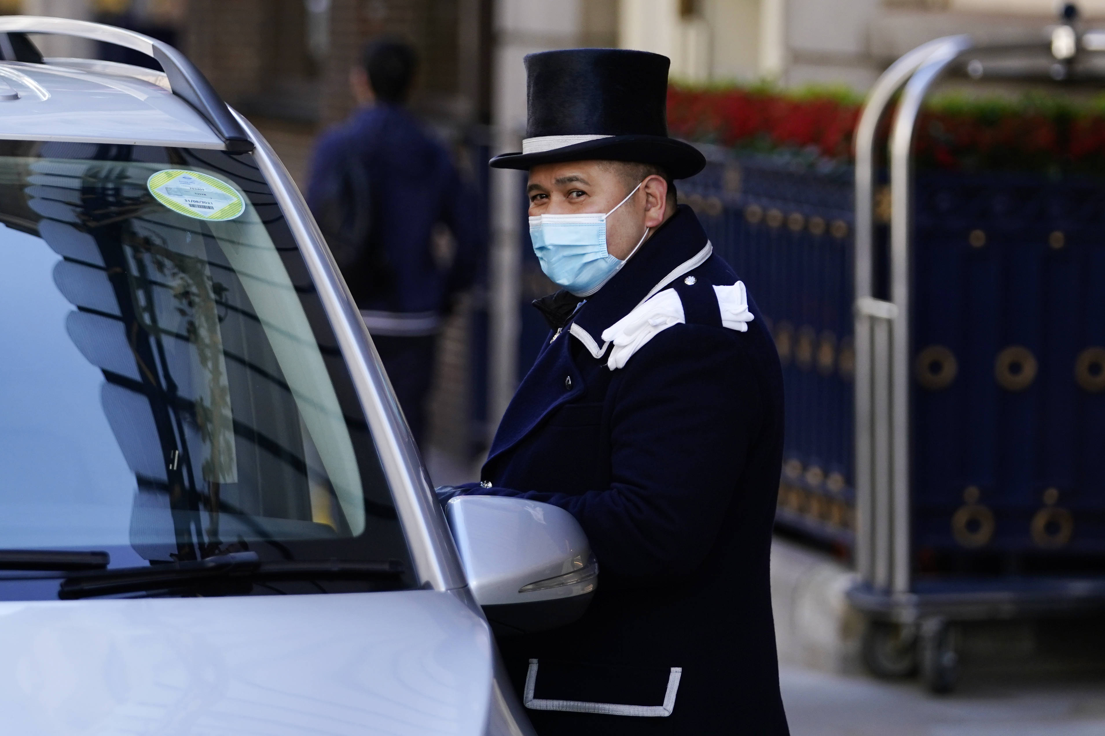 这是10月16日在英国伦敦拍摄的一名戴口罩的酒店服务员.