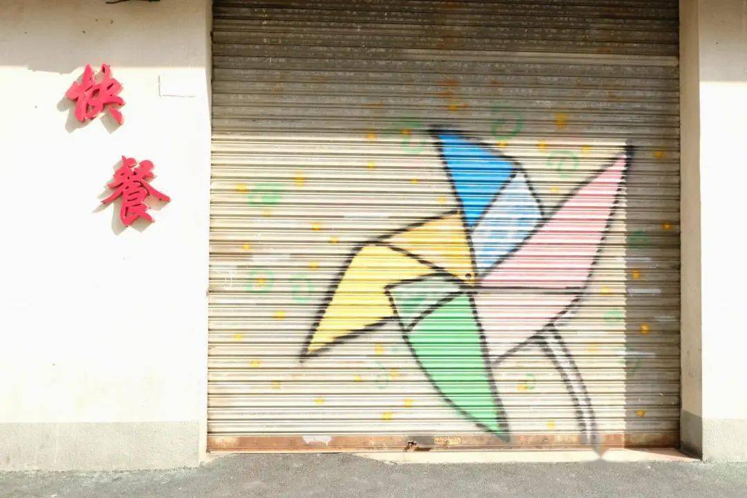 各种各样的彩绘跃然于商铺卷帘门上.