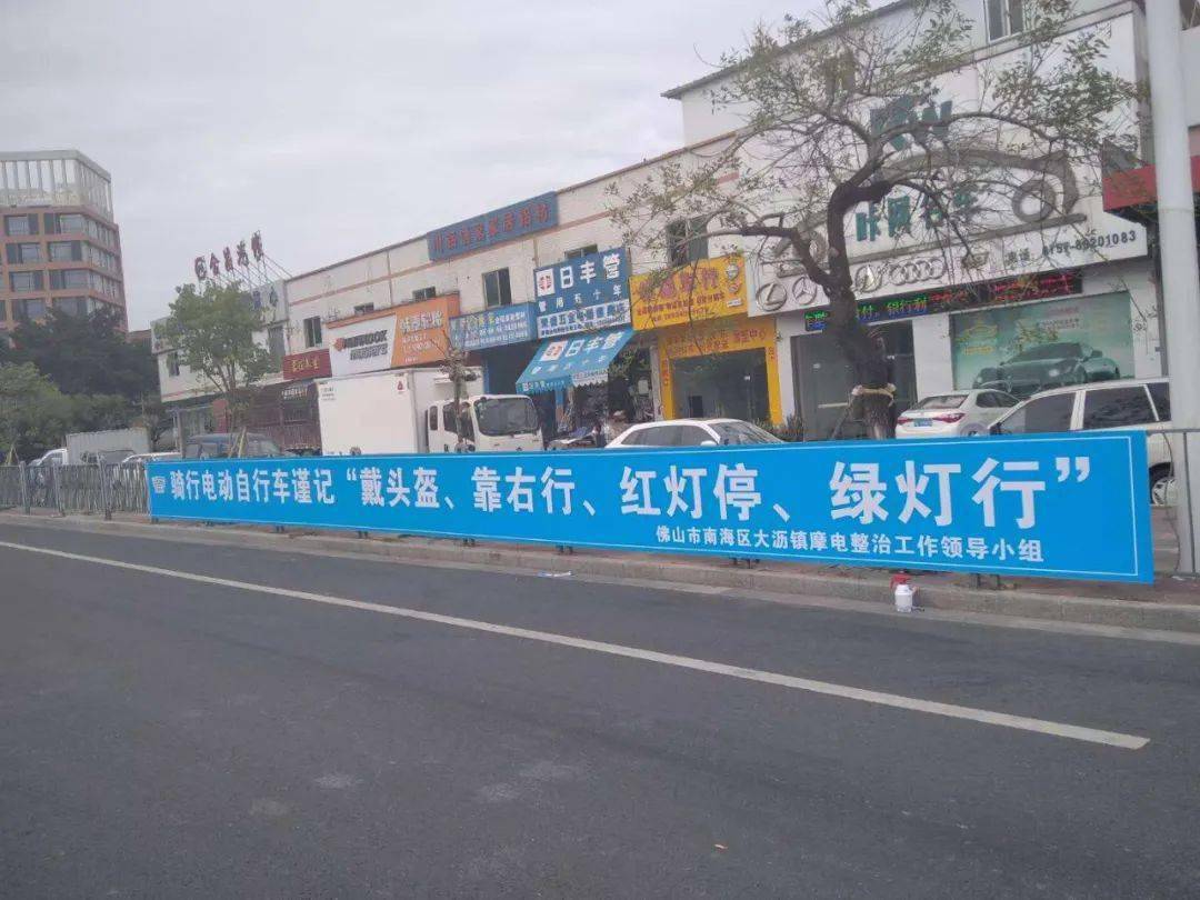 大沥还在镇内道路,公交站亭悬挂横幅,向民众发出规范"摩电"文明出行