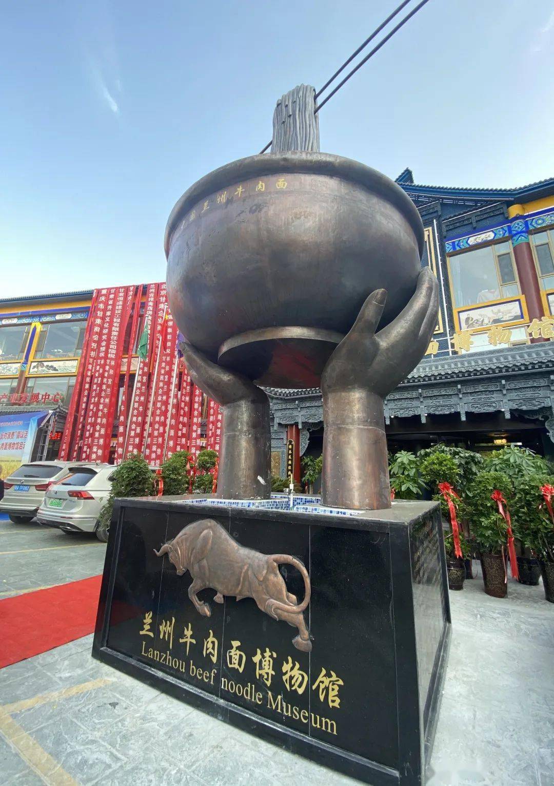 边的红色指示牌和旁边的拉面人物铜雕,记者了解到,该雕塑已成为参观者