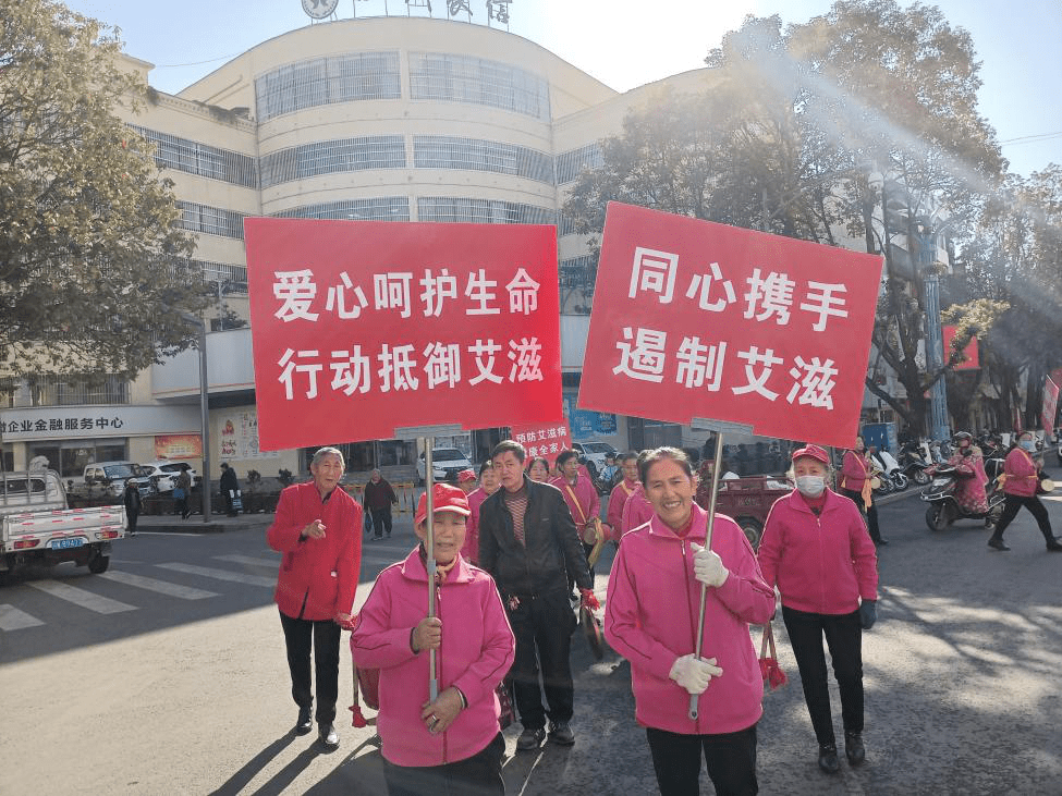 活动现场摆放艾滋病宣传展板,悬挂横幅;宣传员们配带红丝带开展形式