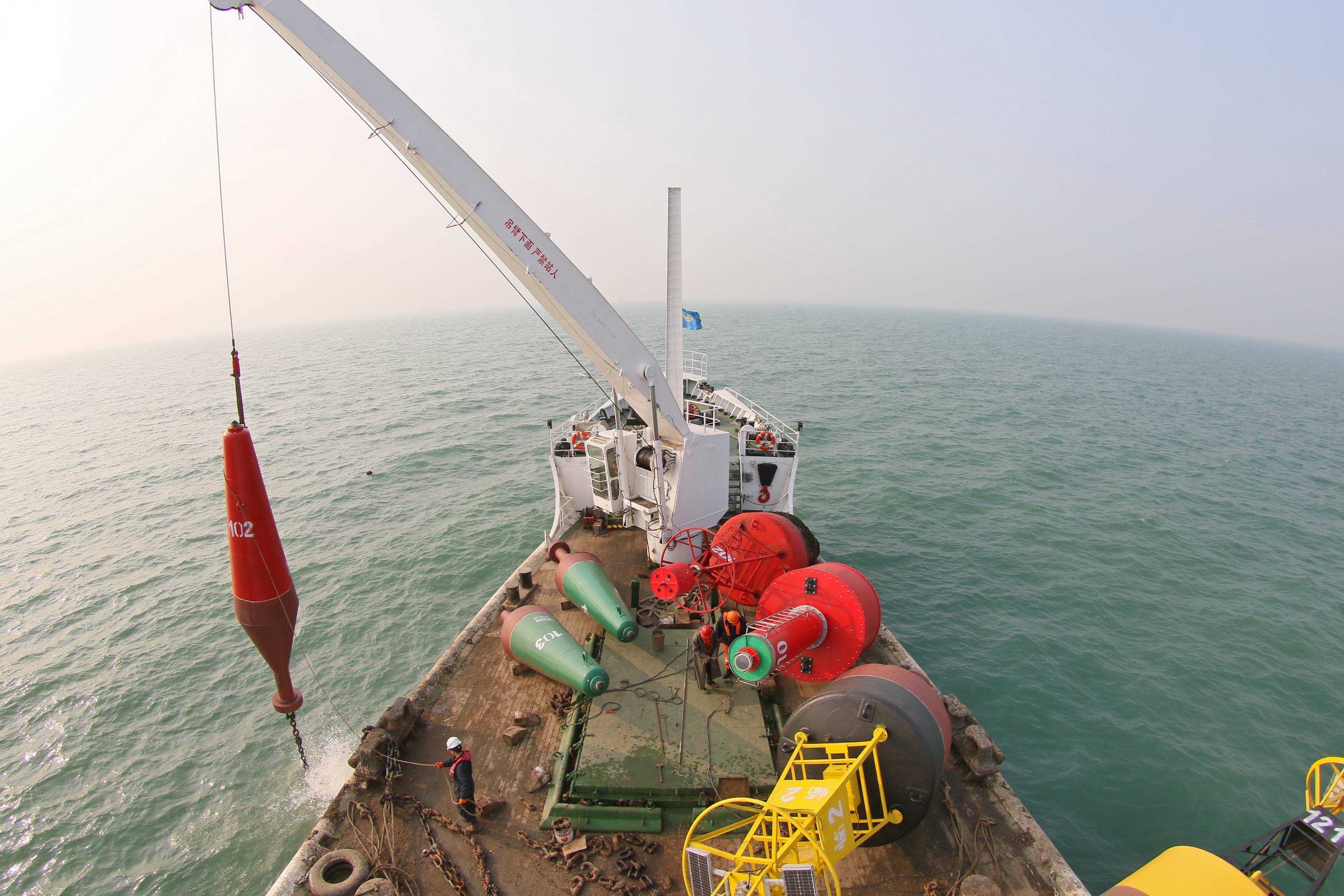 12月6日,在山东烟台龙口港主航道,航标船在投放冰期航标.