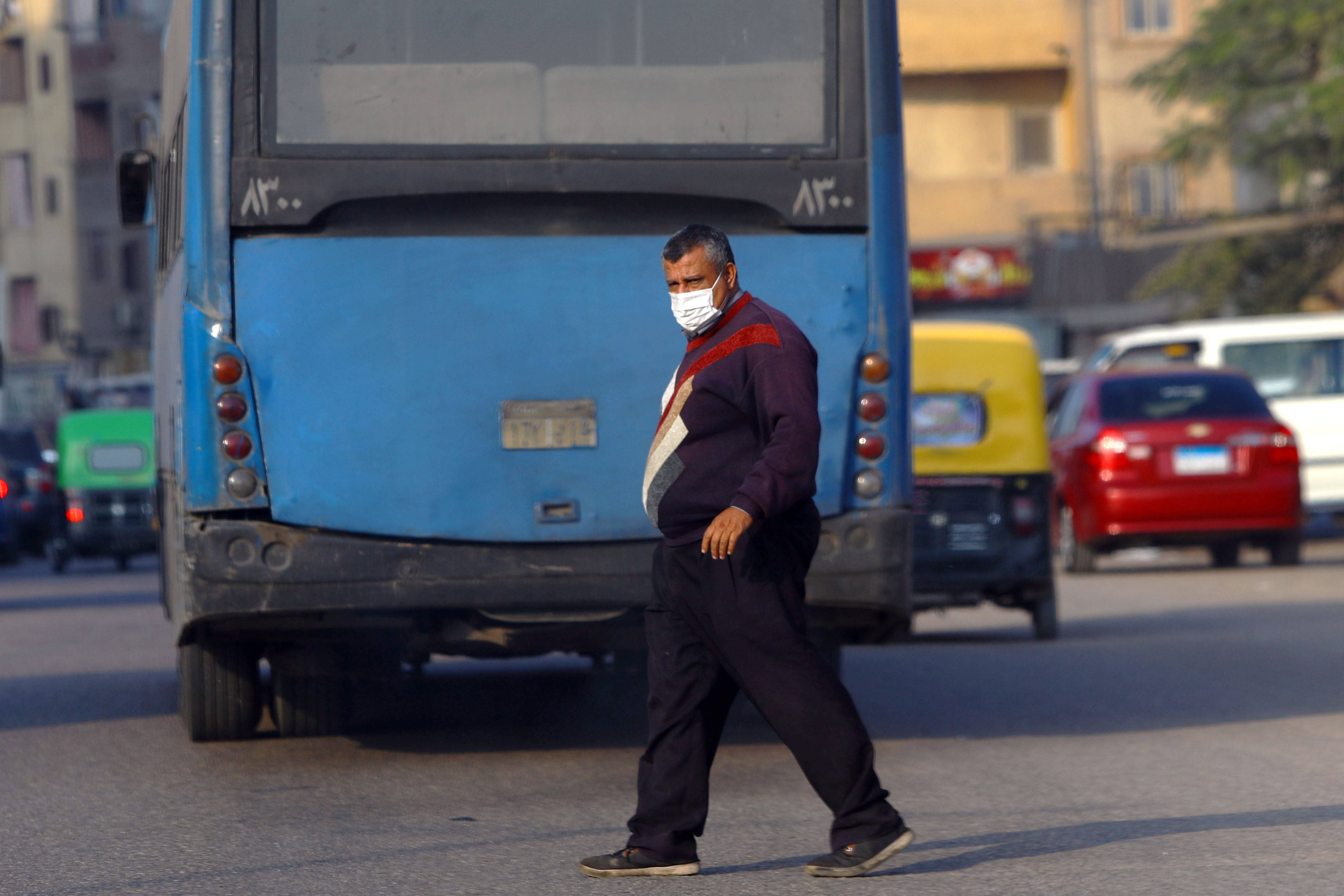 1月3日,一名戴口罩的男子走过埃及开罗街头.