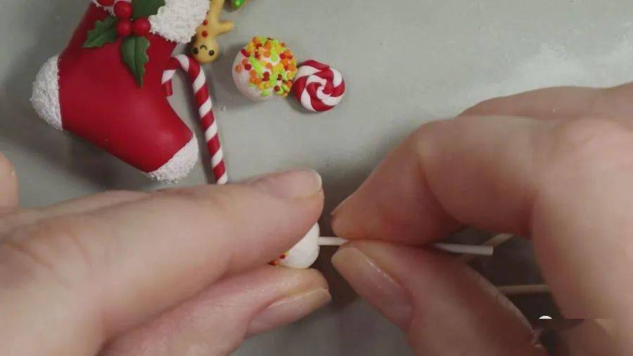 在圣诞靴内填入铝箔团,再覆盖白色软陶泥,将糖球插入其中.