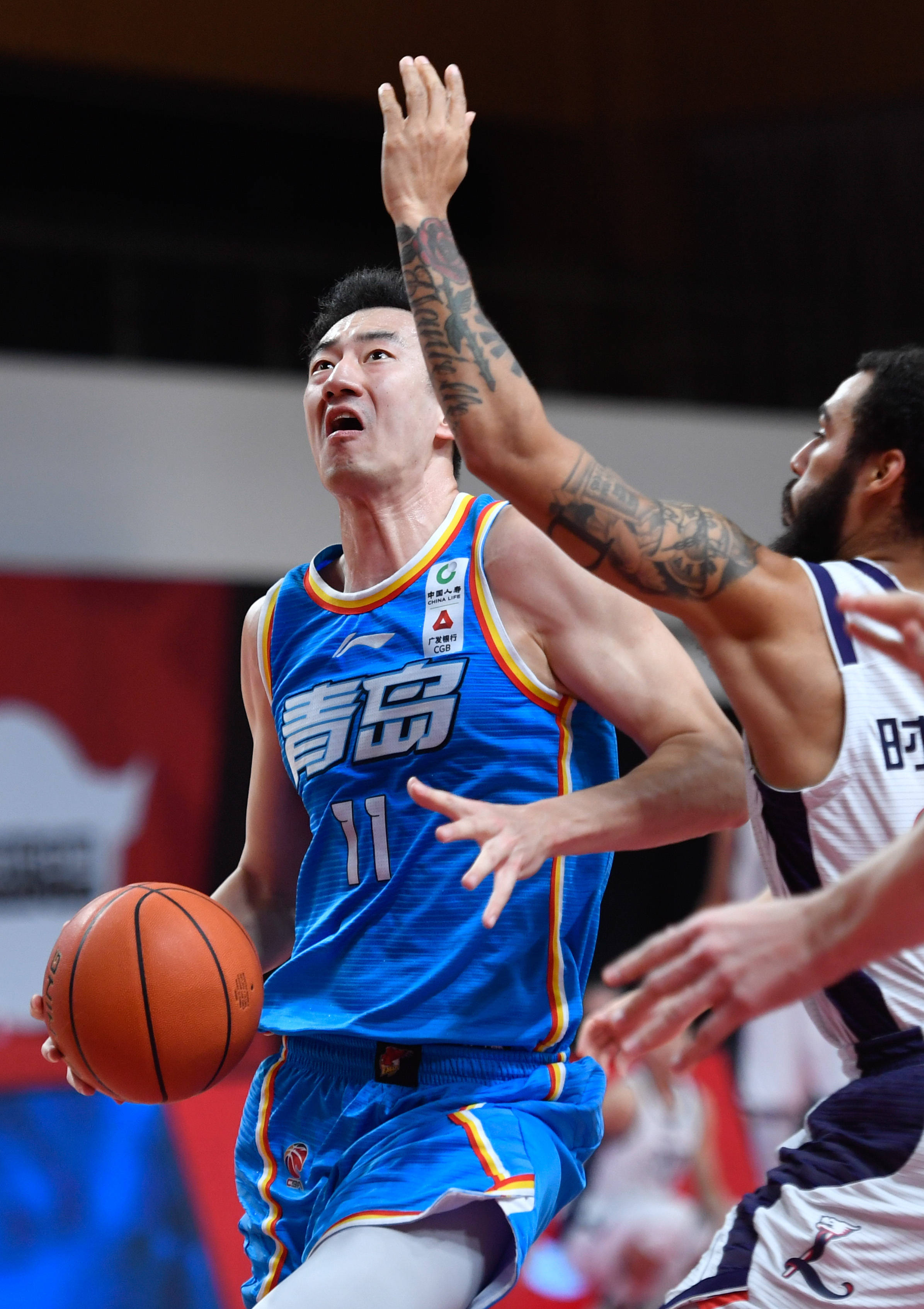 1月26日,青岛每日优鲜队球员邵英伦(左)运球进攻.