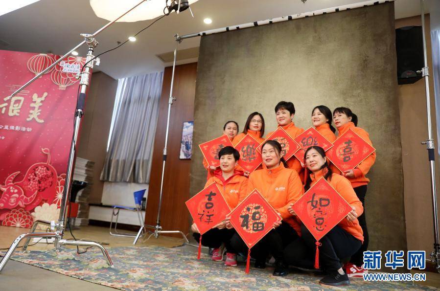 2月4日,家政阿姨们手拿新年祝福装饰板拍摄合影.新华社记者 方喆 摄