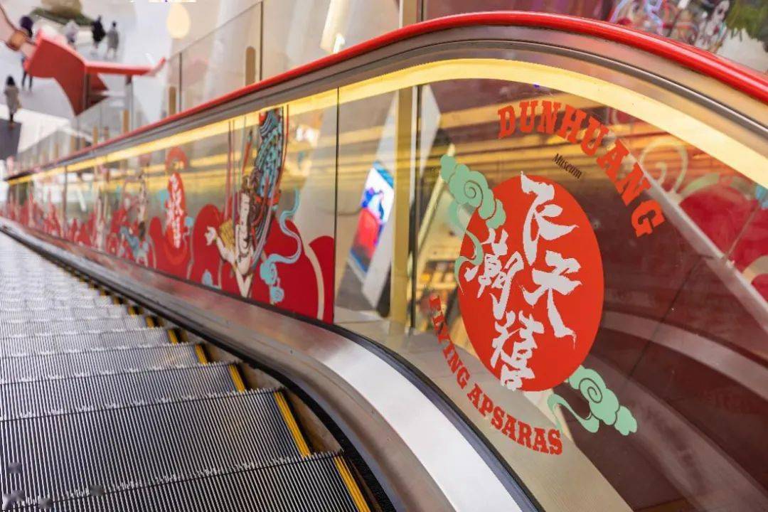 连扶梯扶手侧都精心布置了"飞天潮禧"主题的氛围.