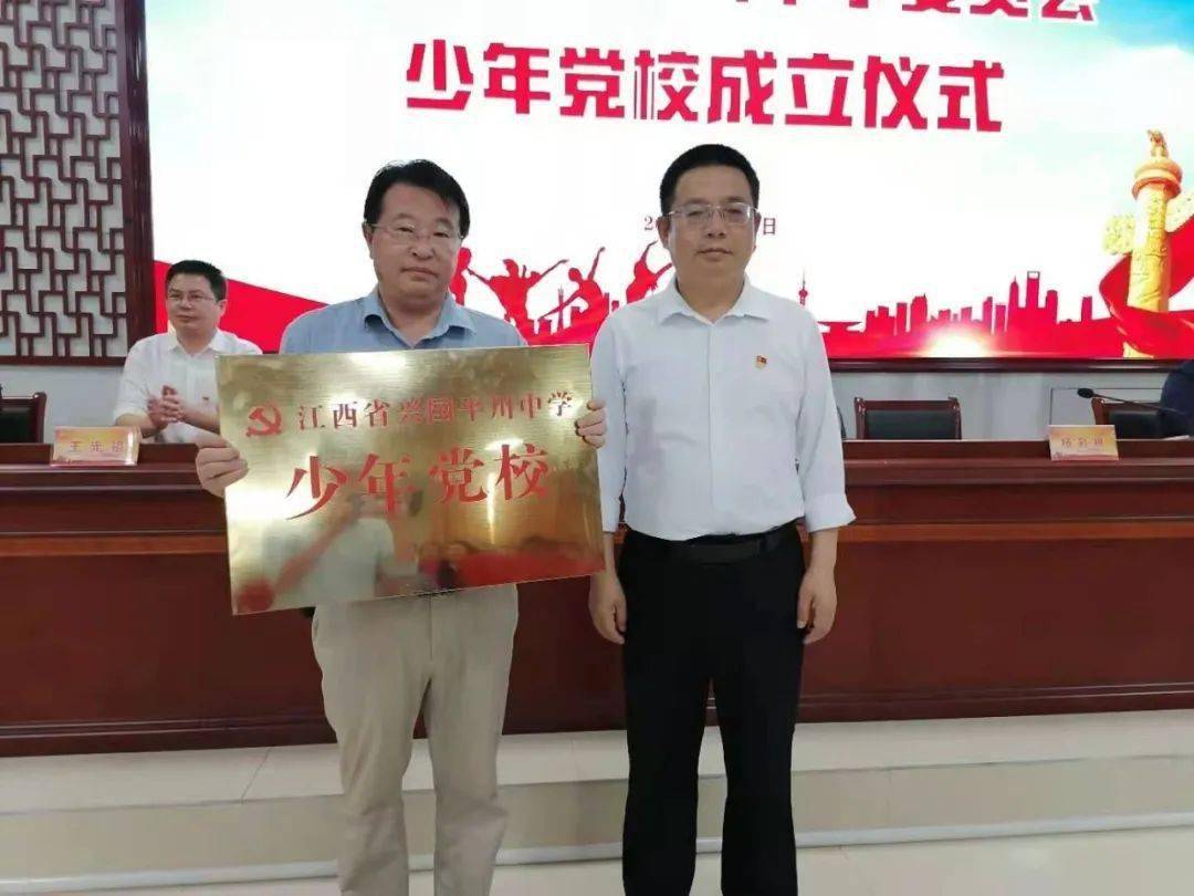 校党委书记,校长李忠明向少年党校校长杨彩根授予"少年党校"校牌.