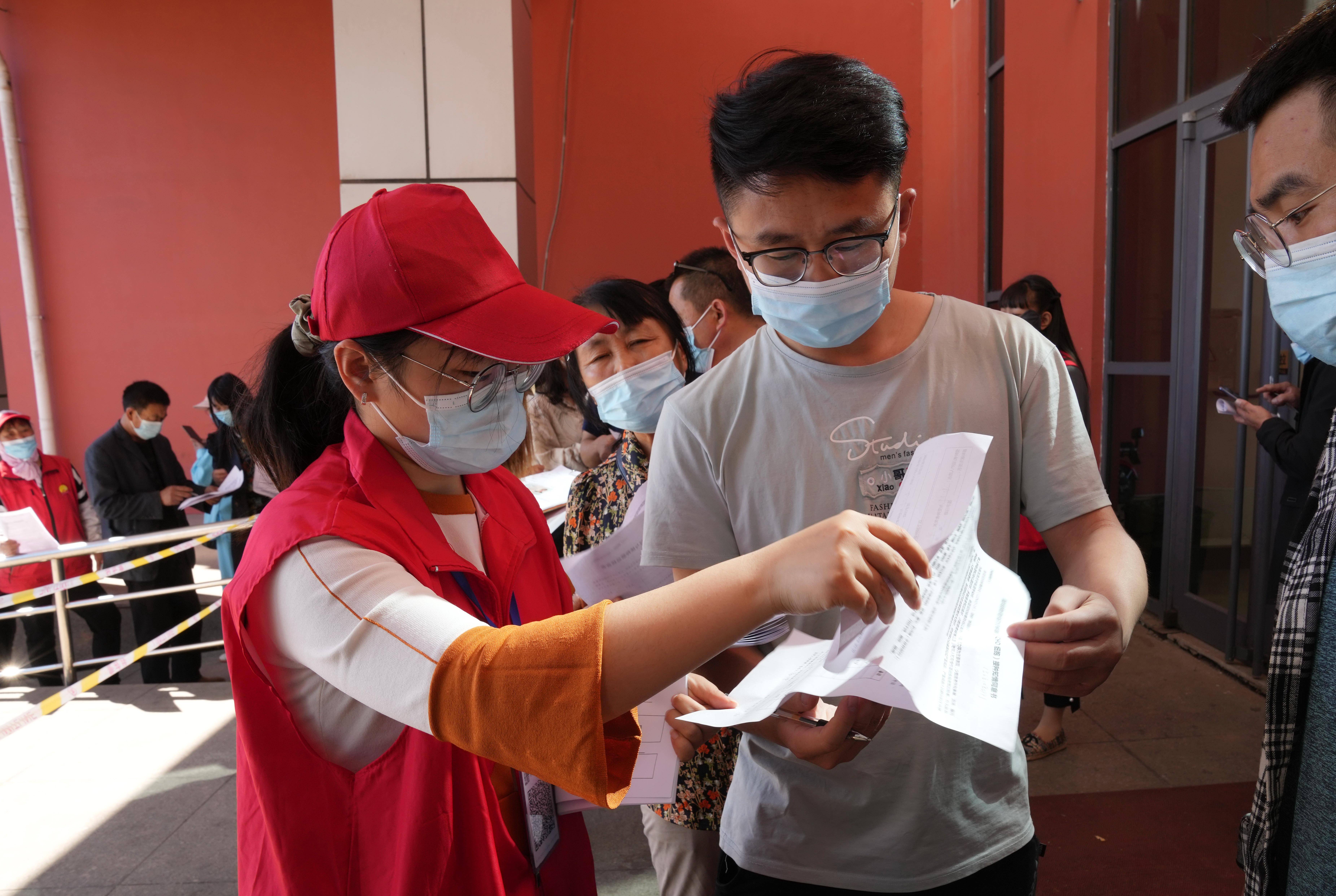 5月28日,在唐山市海港經濟開發區體育館新冠疫苗接種點,志願者在指導