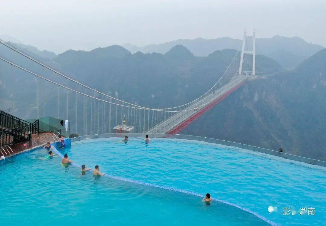矮寨镇天桥仙居民宿客栈,游客在无边际泳池里远眺矮寨大桥美. .