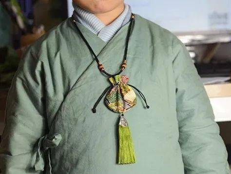 端午节老人为小孩佩戴香囊,有避邪驱瘟之意.