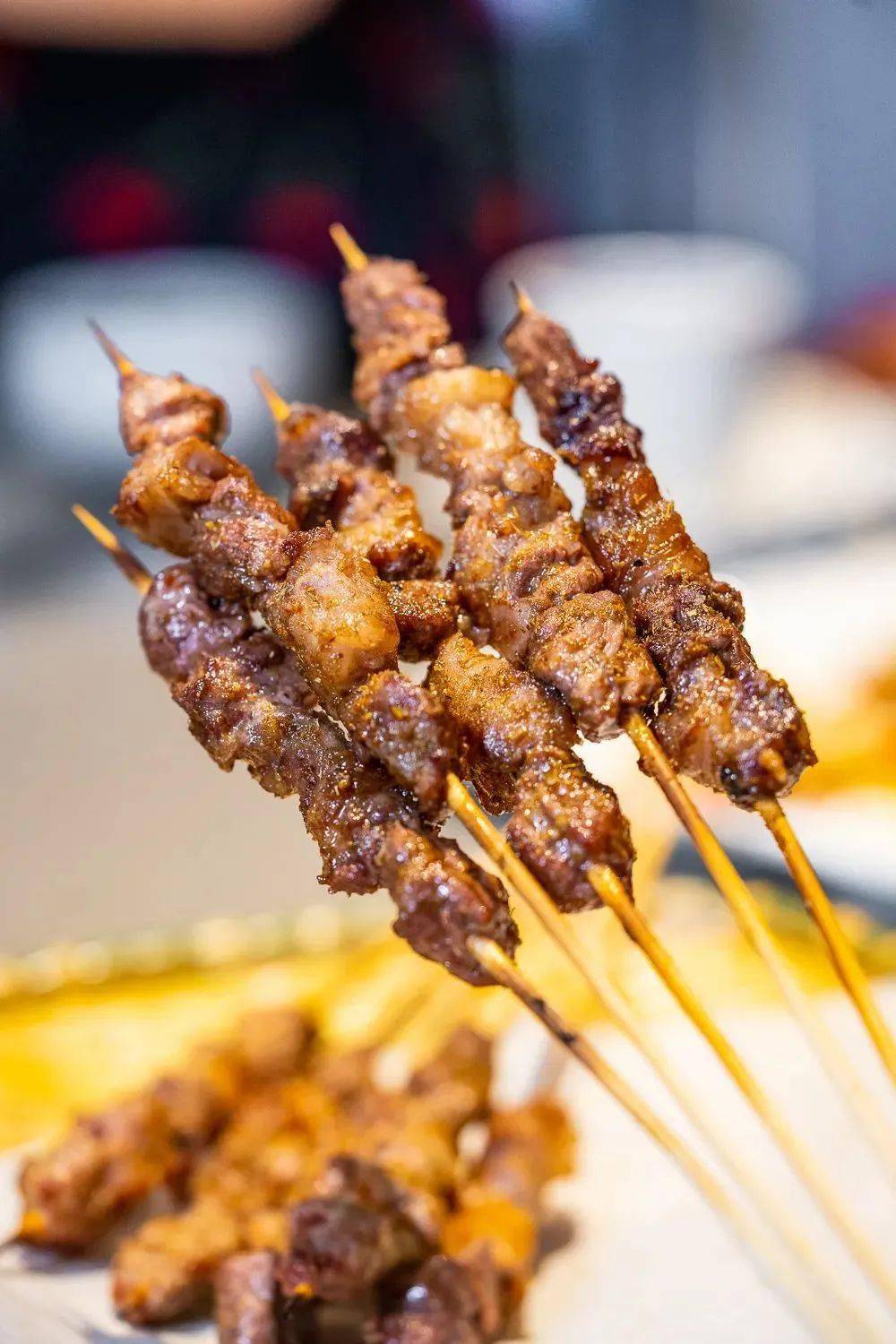 烤制时紧致的牛肉被炭火烤得滋滋作响,油脂渗出,肉汁锁住,一口一个