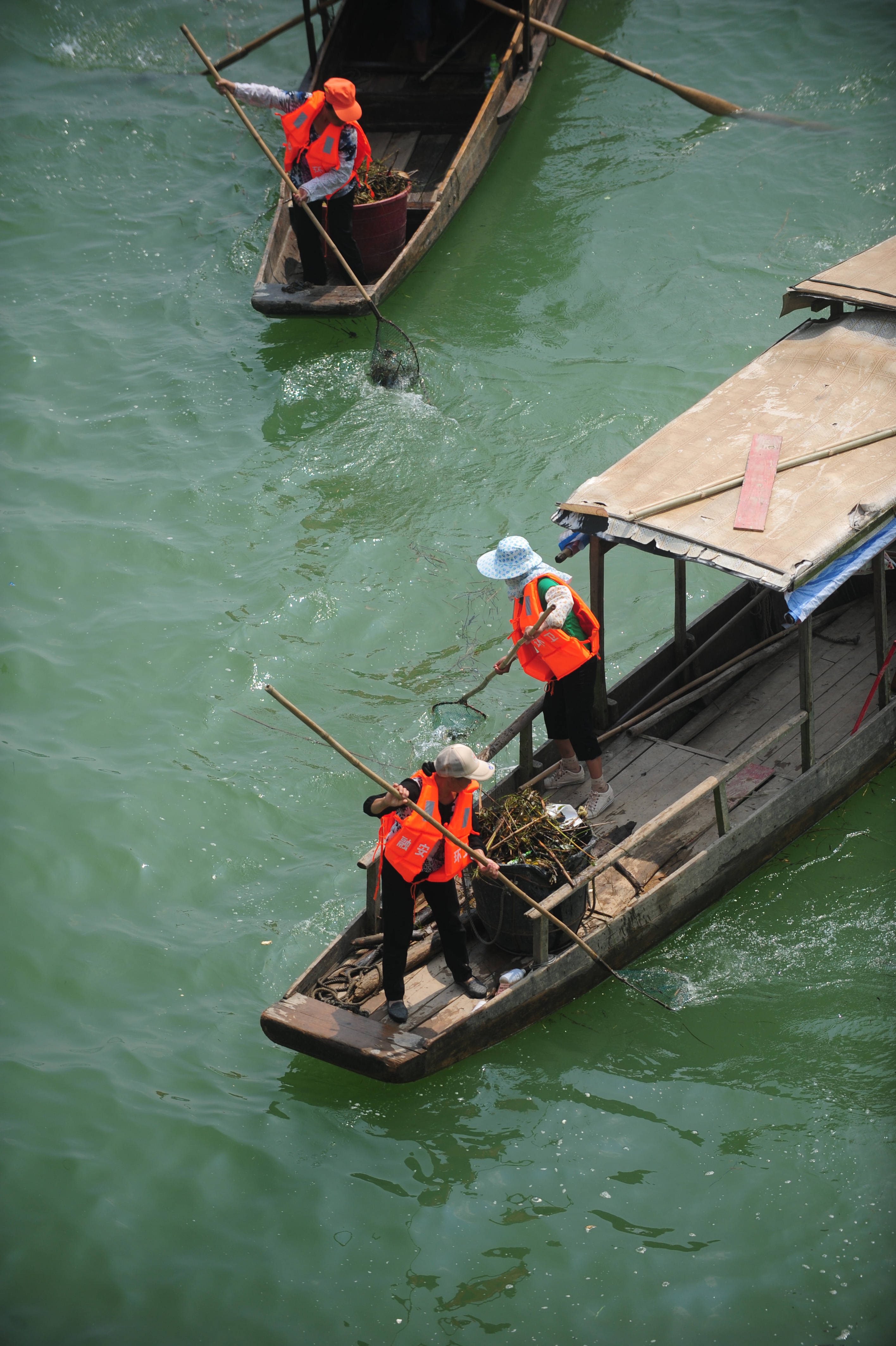 在柳江上游的融江广西融安县城河段,水上保洁队员在清理河面上的垃圾