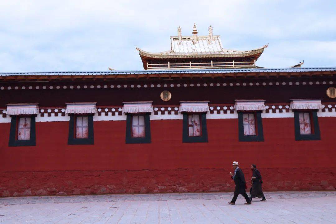 看着藏红色僧服的喇嘛与朝拜的信徒们在黄,白,红色的墙壁之间若隐若现