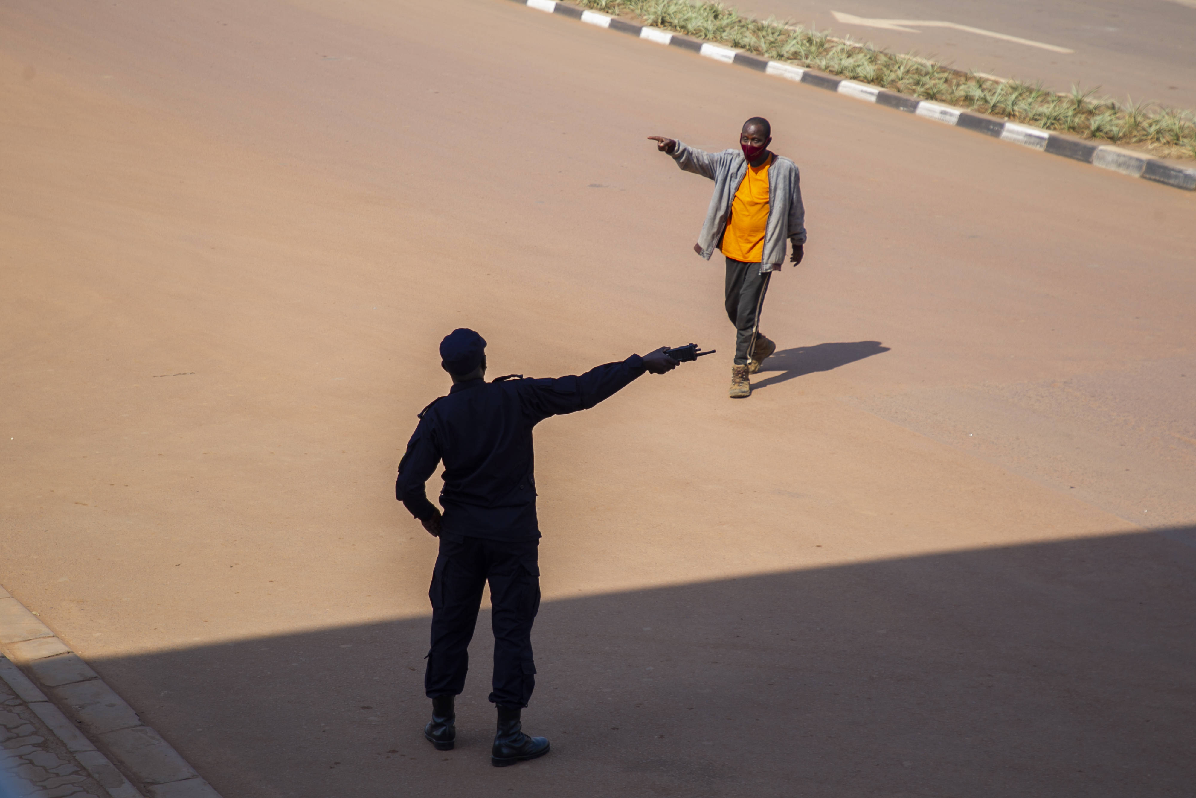 7月17日,在卢旺达首都基加利,警察在"禁足令"期间同街上的一名行人