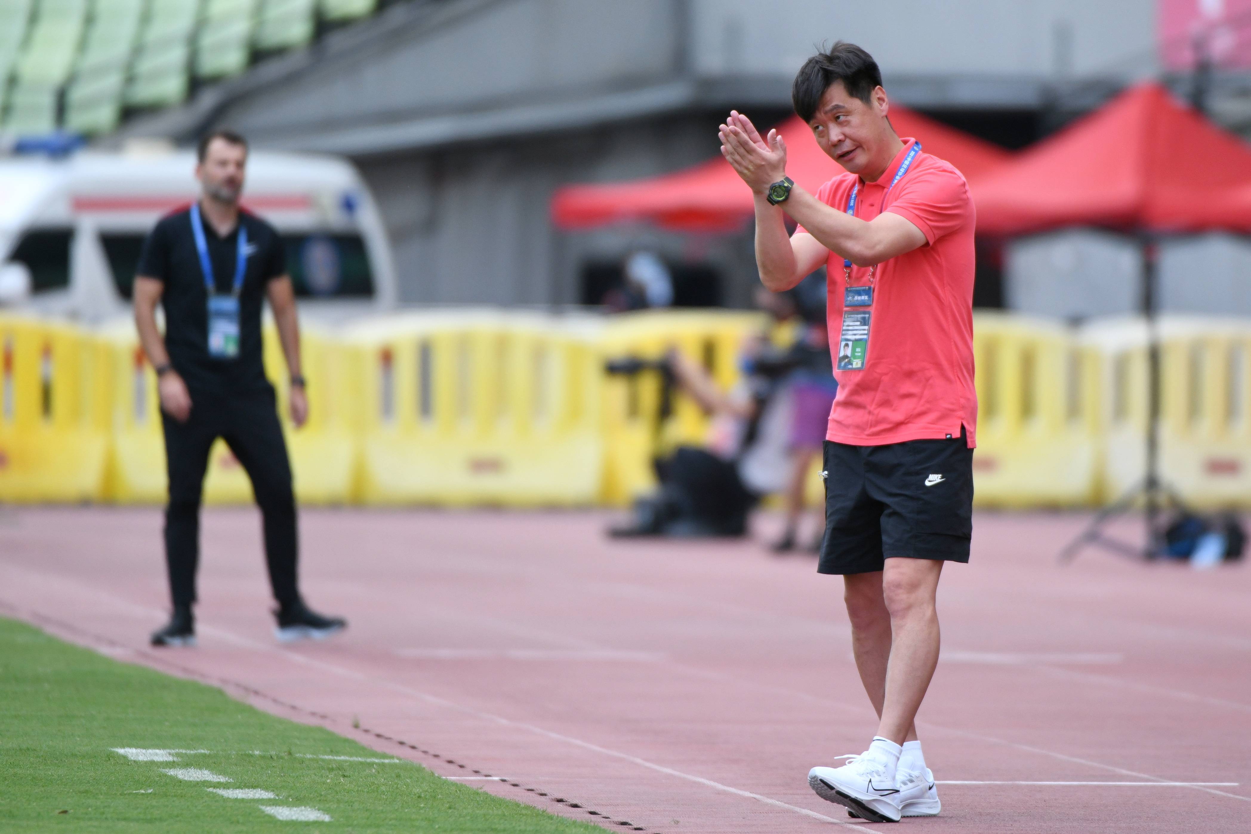 7月19日,武汉队主教练李霄鹏(右)在比赛中给球员鼓掌.